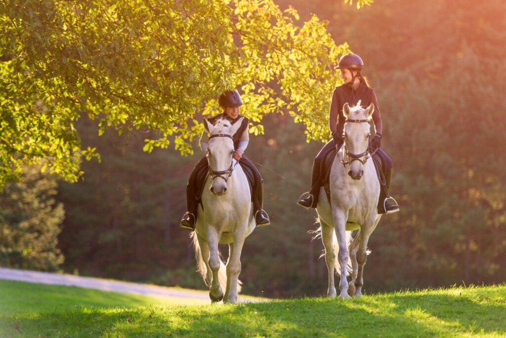 Casteljaloux : activités à découvrir week-end. Deux femmes en train de faire une balade à cheval dans la campagne de Casteljaloux